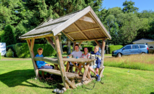 Familie zit rond picknicktafel op Camping Lotje