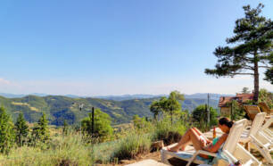 A woman relaxing on a deck chair and reading a book.