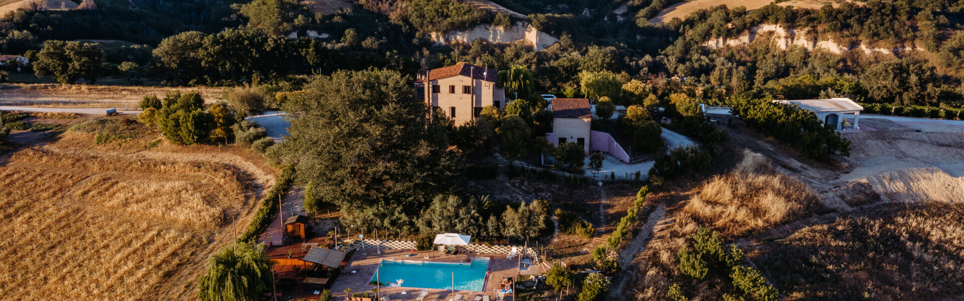 Luchtfoto Agricola la Casetta tussen de heuvels in Italië zwembad