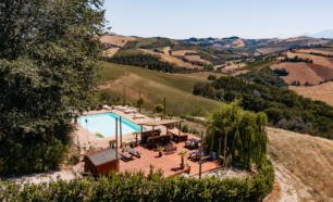 Zwembad bar terras met heuvels op de achtergrond Agricola la Casetta Marche