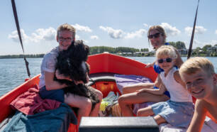 Familie met hond op boot varen op Brielse meer Camping de Krabbeplaat