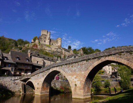 Oude brug over rivier en oud kasteel op heuveltop