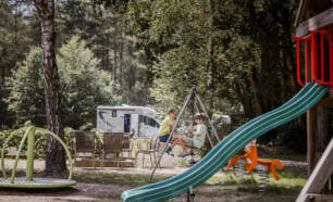 Kinderen op de schommel in speeltuin van Camping Siësta